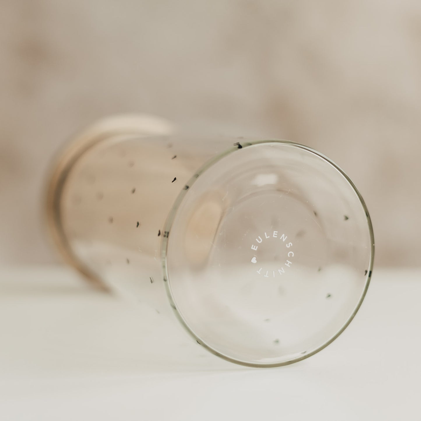 Liegendes Vorratsglas mit schwarzen Herzen und Eulenschnitt-Logo auf dem Glasboden.