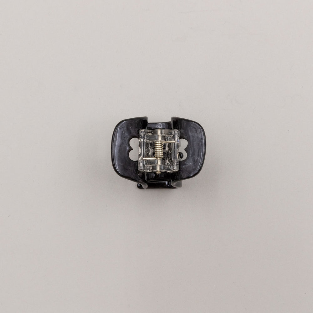 Unterseite der schwarzen Haarspange mit Metallfeder und Herz-Details – stabil und funktional.