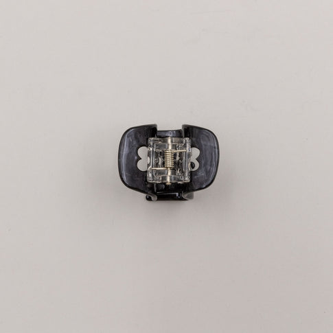 Unterseite der schwarzen Haarspange mit Metallfeder und Herz-Details – stabil und funktional.