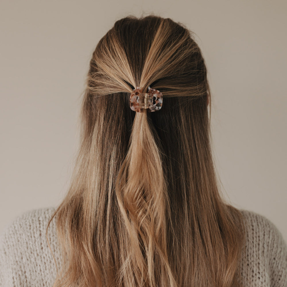 Frau mit Half-Up-Frisur und eingesetzter Haarspange Herz Almond in zarten Mandel- und Rosétönen