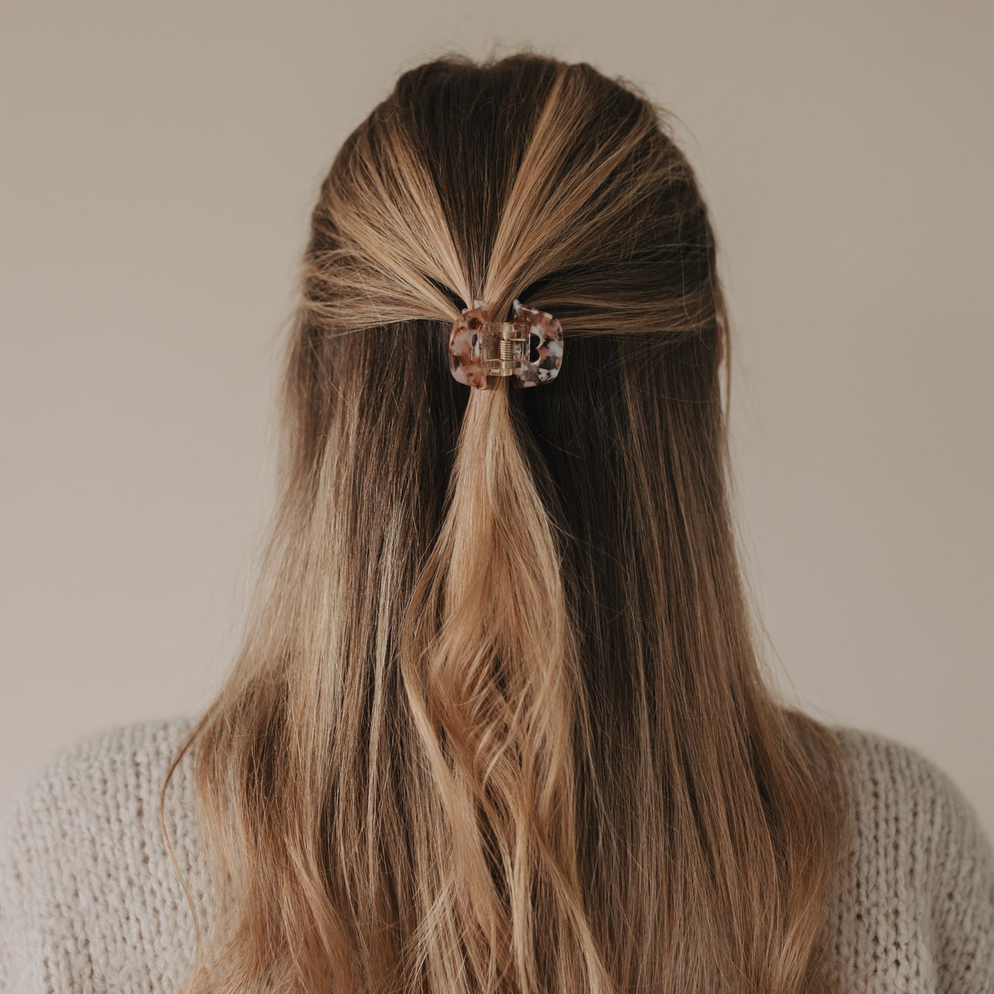 Frau mit Half-Up-Frisur und eingesetzter Haarspange Herz Almond in zarten Mandel- und Rosétönen