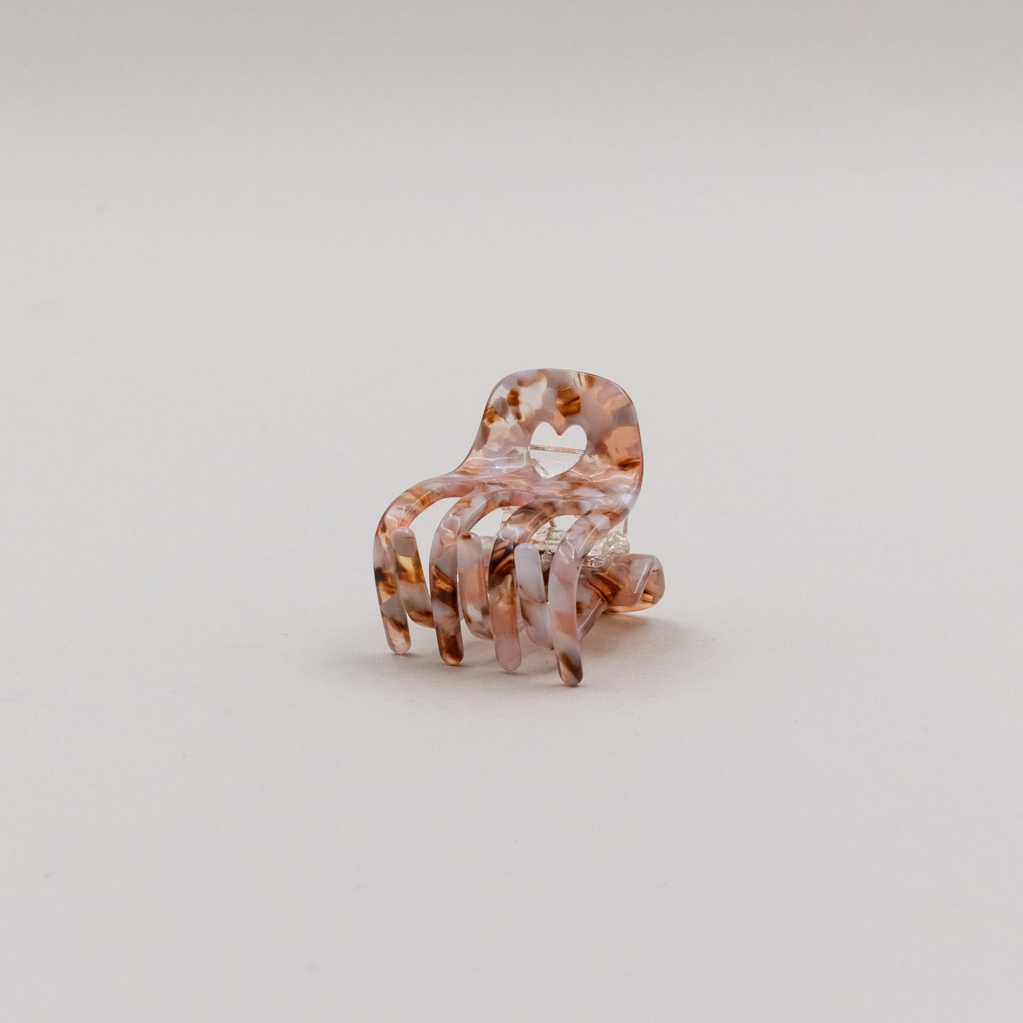 Kleine Haarspange Herz Almond in zartem Marmorlook mit Herzdetail, freigestellt vor neutralem Hintergrund