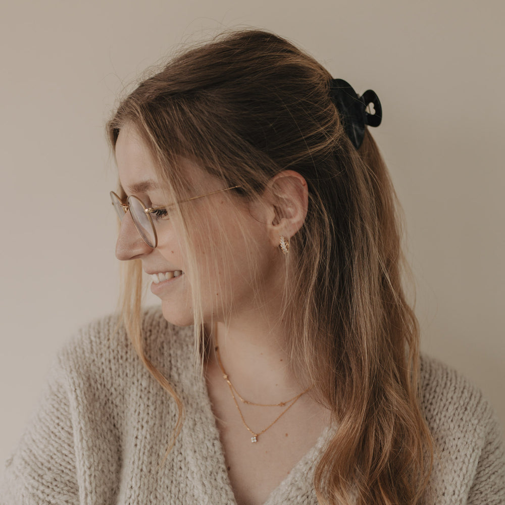 Frau mit halboffener Frisur und großer Haarspange Herz night von hinten