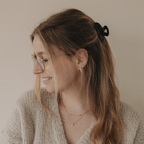 Frau mit halboffener Frisur und großer Haarspange Herz night von hinten