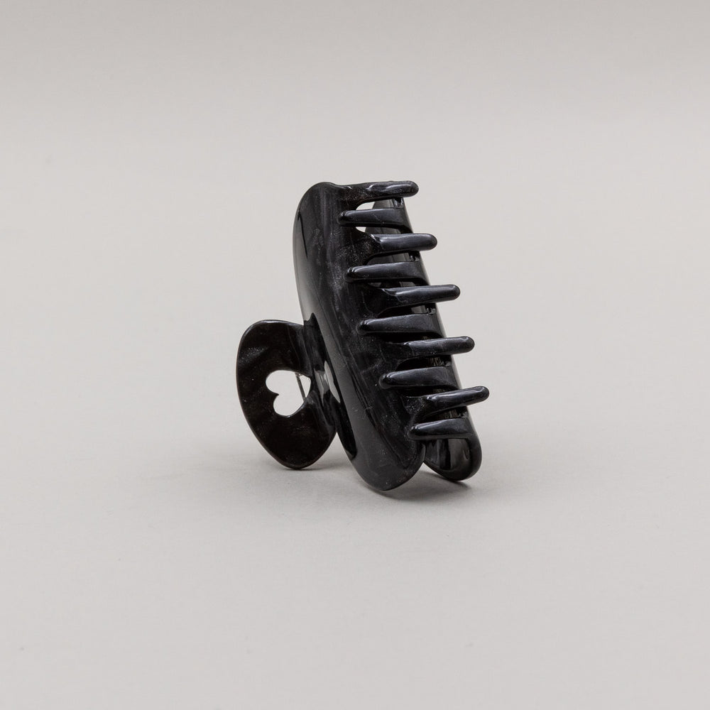 Kleine Haarspange in Schwarz mit herzförmigem Griff, seitlich aufgestellt.