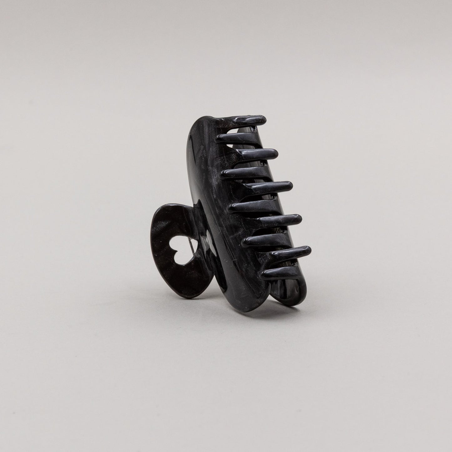 Kleine Haarspange in Schwarz mit herzförmigem Griff, seitlich aufgestellt.
