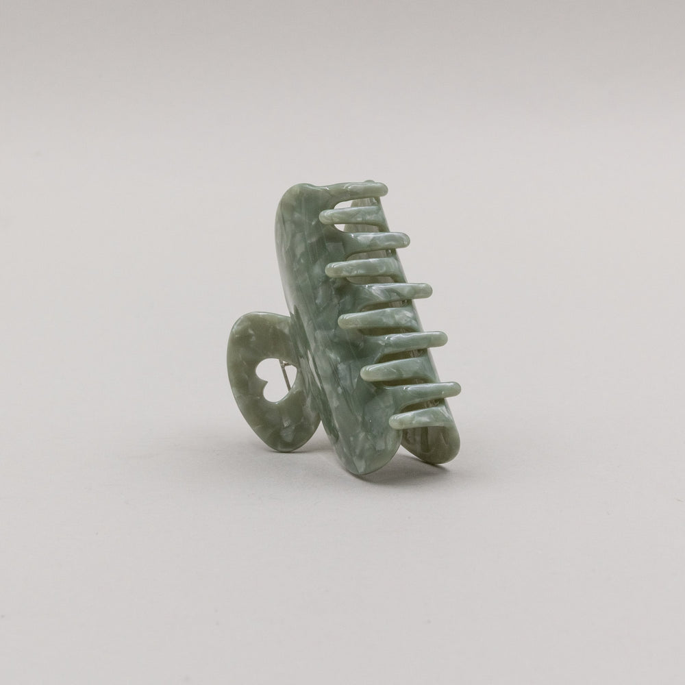 Große Haarspange Jade in elegantem Grün mit Herzdetail, Seitenansicht der geöffneten Spange auf hellem Untergrund