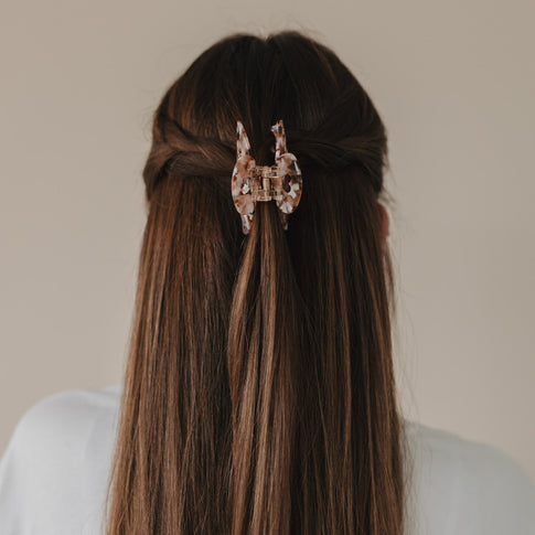 Blick auf große Haarspange Herz Almond in marmorierter Optik im braunen Haar.