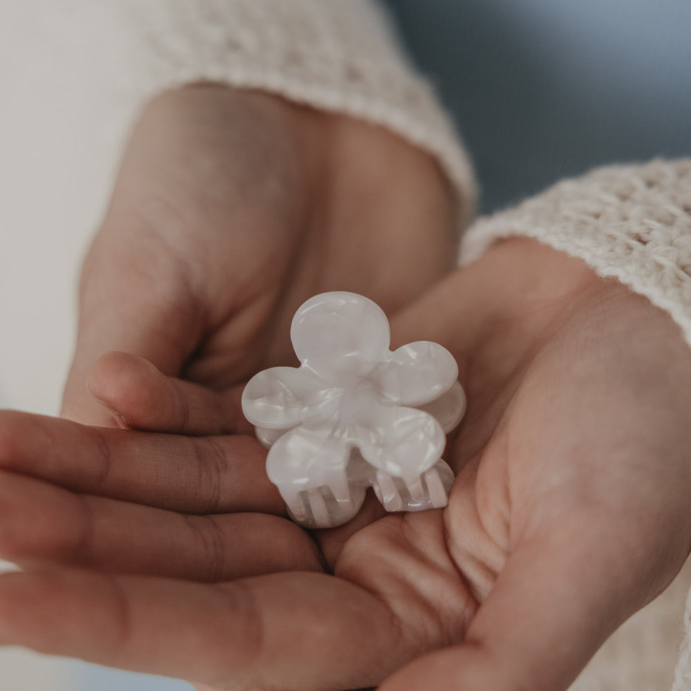 Haarspange Blume in Perlmutt-Optik wird im Haar befestigt von Hand