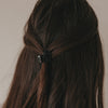 Rückansicht kleine Haarspange in Herzform schwarz im halboffenen Haar