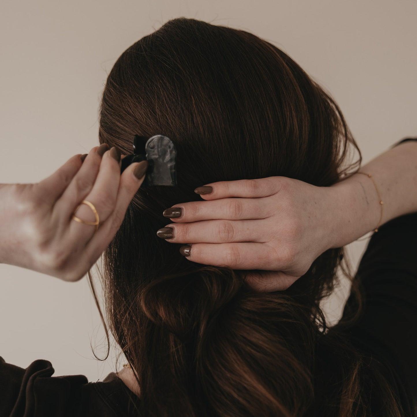Hände befestigen große schwarze Haarspange in Herzform im Haar