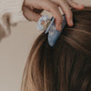 Große blaue Haarspange mit Herzdetail wird im Haar befestigt
