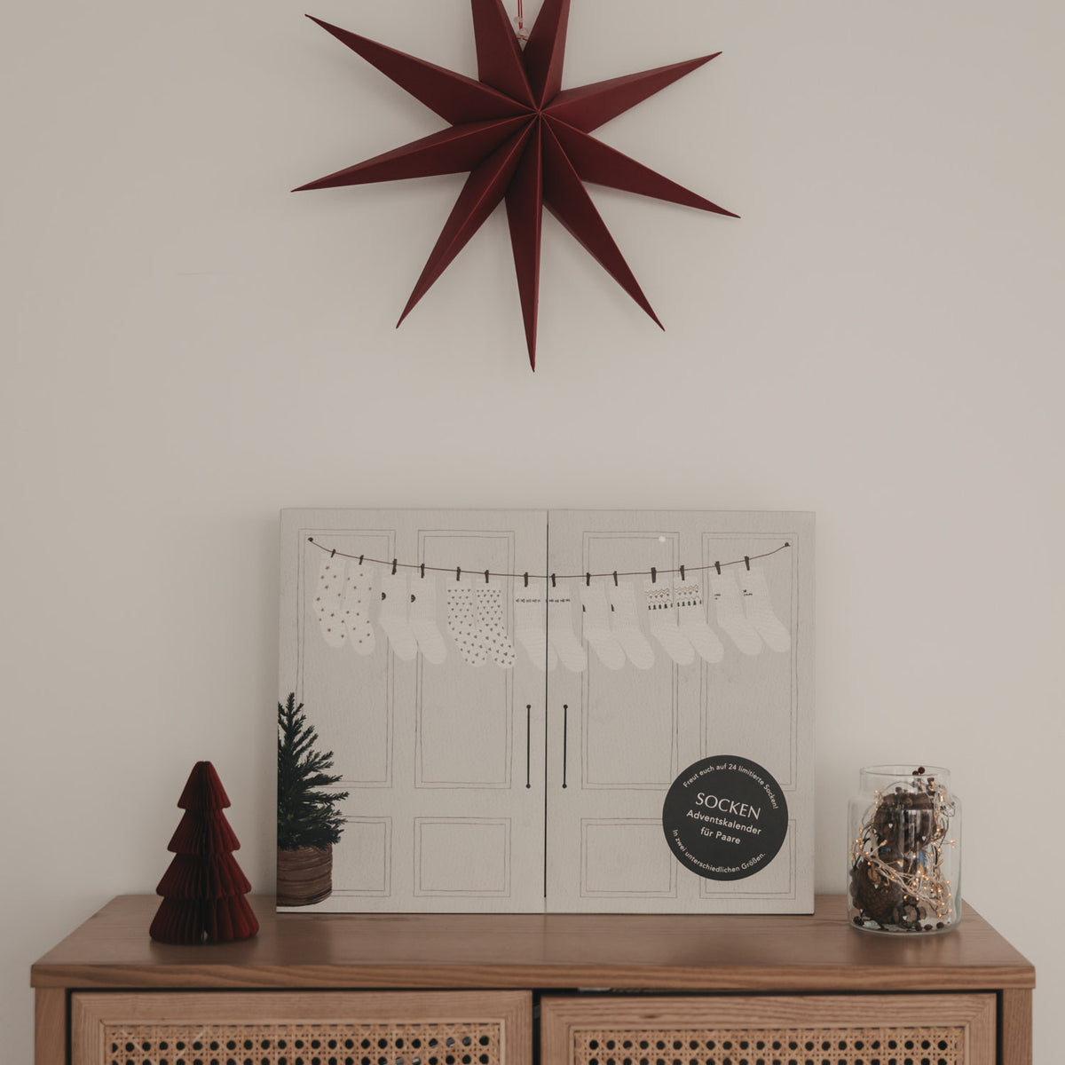Eulenschnitt Socken-Adventskalender für Paare dekoriert mit Weihnachtsstern und Lichterkette