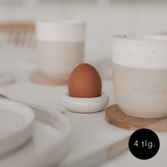 Minimalistischer Eulenschnitt Eierbecher Calma mit braunem Ei auf gedecktem Tisch, 4-teiliges Set.
