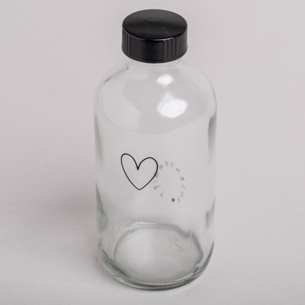 Wiederverwendbare Glasflasche mit schwarzem Schraubdeckel und Herzaufdruck – perfekt für nachhaltiges Nachfüllen
