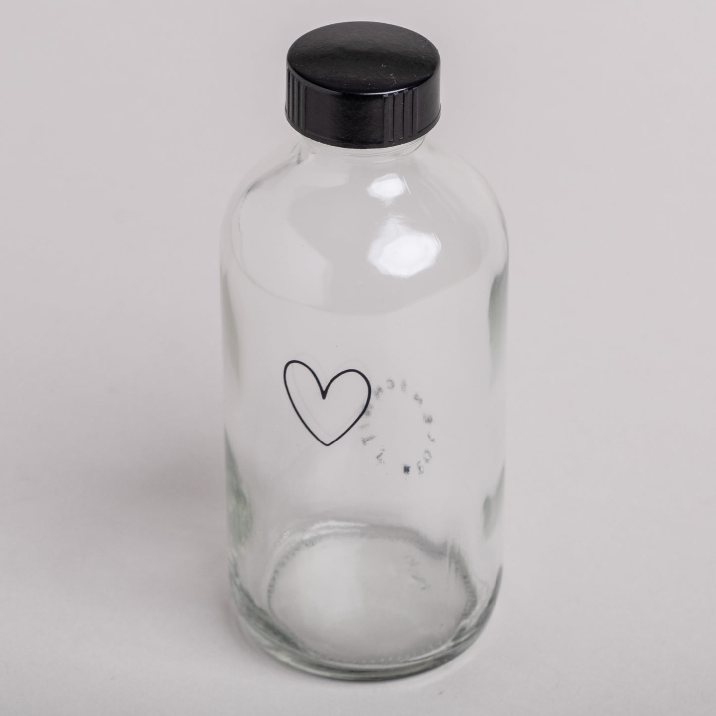 Wiederverwendbare Glasflasche mit schwarzem Schraubdeckel und Herzaufdruck – perfekt für nachhaltiges Nachfüllen