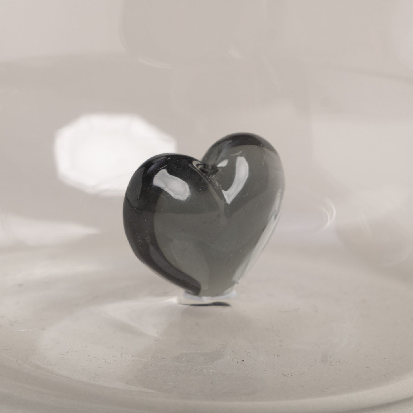 Detailaufnahme eines Trinkglases mit schwarzer Herzfigur.
