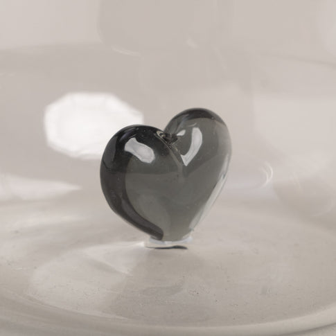 Detailaufnahme eines Trinkglases mit schwarzer Herzfigur.