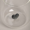 Detailaufnahme des Trinkglases mit schwarzer Herzfigur.