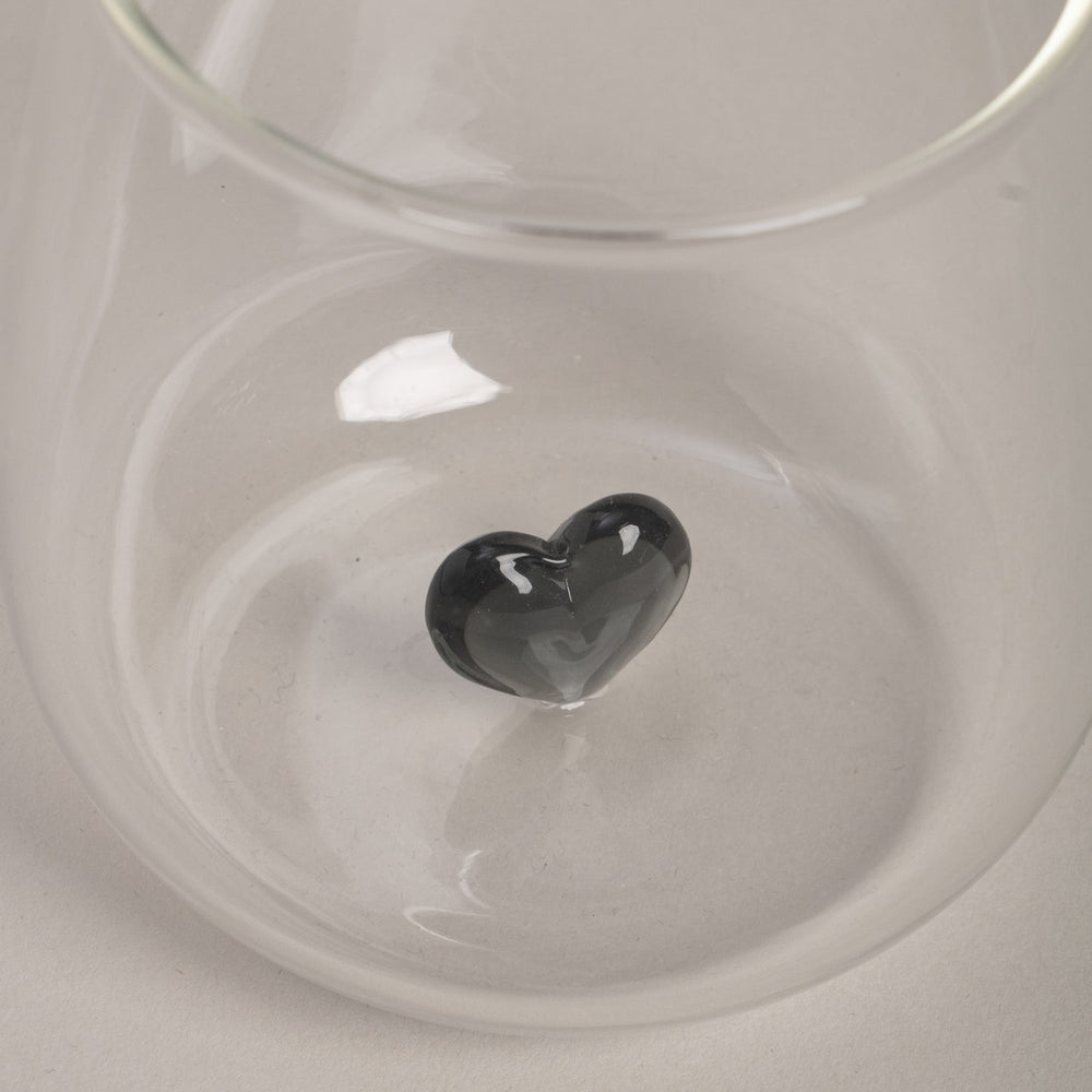 Detailaufnahme des Trinkglases mit schwarzer Herzfigur.