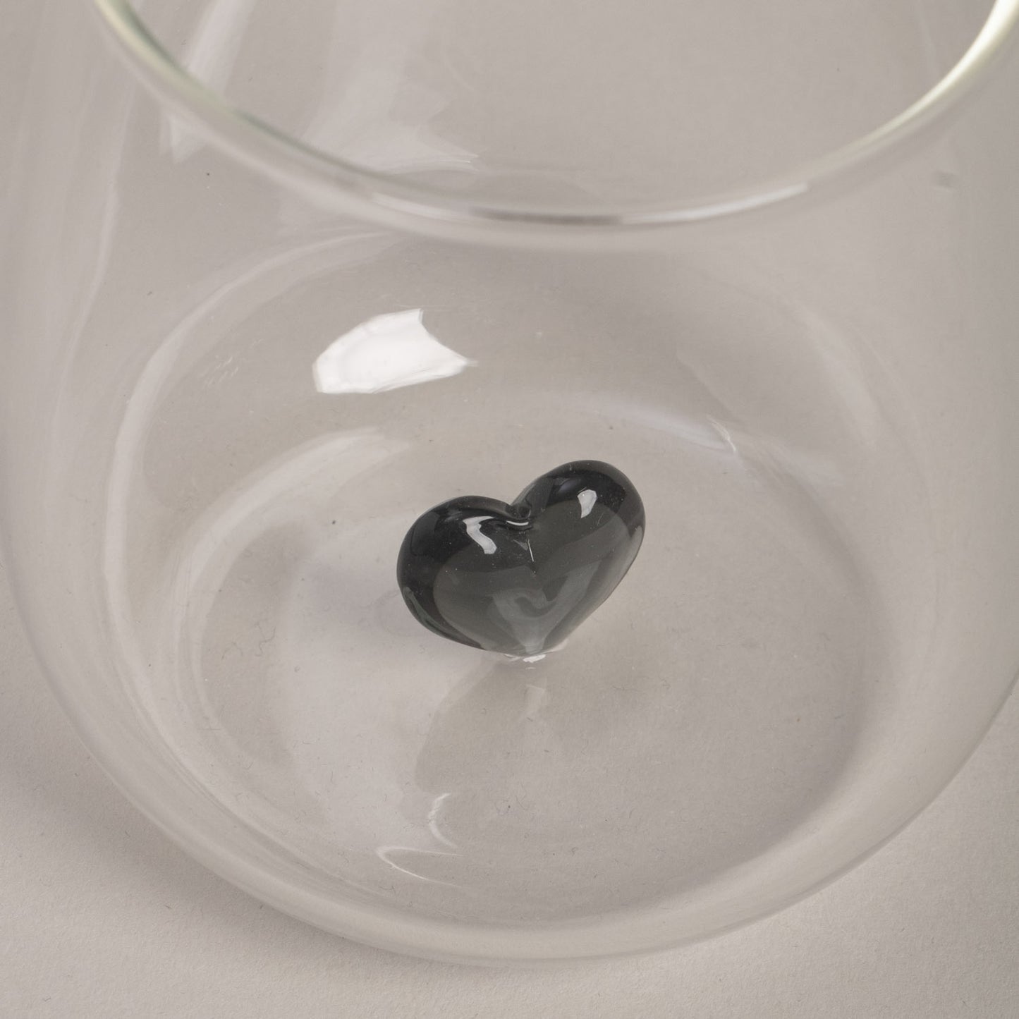 Detailaufnahme des Trinkglases mit schwarzer Herzfigur.