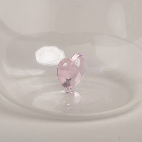 Figurglas mit rosa Herzform in der Mitte als dekoratives Element im Trinkglas.