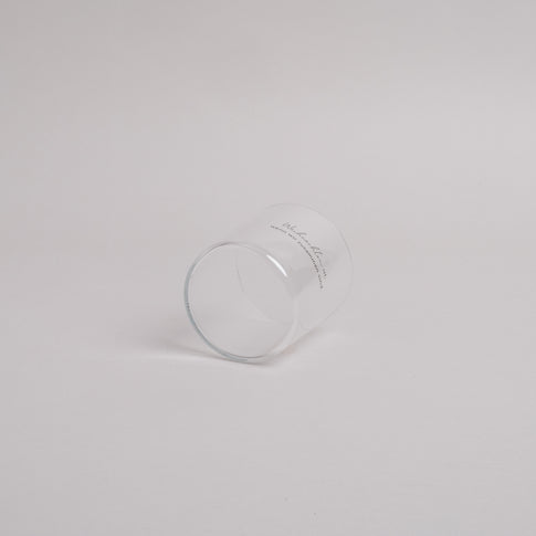 Trinkglas mit schwarzem Schriftzug „Weihnachten ist, wenn wir zusammen sind.“ – seitlich liegend fotografiert, schlichtes Weihnachtsdesign.