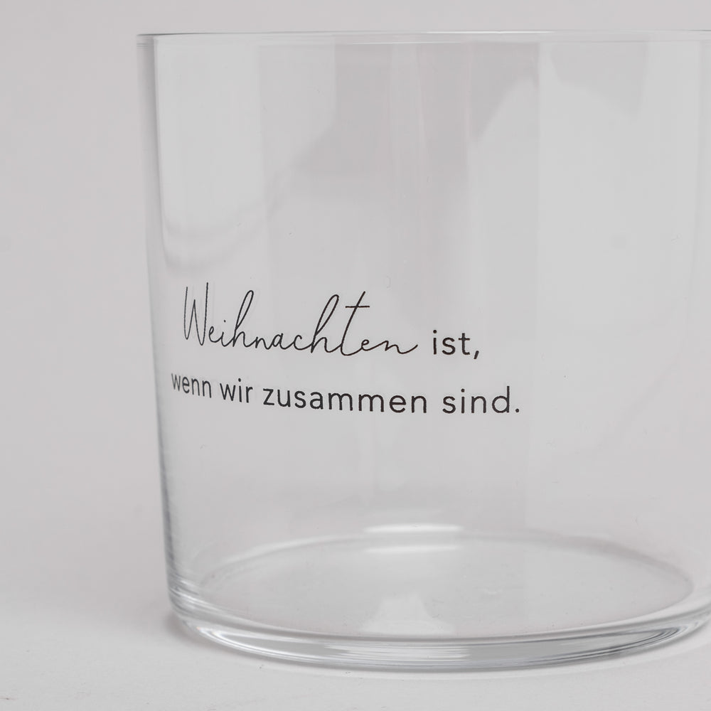 Nahaufnahme eines Trinkglases mit schwarzer Gravur ‚Weihnachten ist, wenn wir zusammen sind‘ – festliches Glas für die Weihnachtszeit