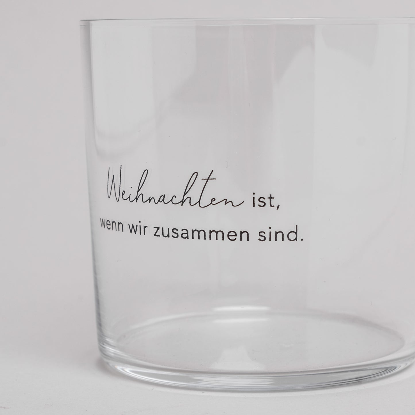 Nahaufnahme eines Trinkglases mit schwarzer Gravur ‚Weihnachten ist, wenn wir zusammen sind‘ – festliches Glas für die Weihnachtszeit