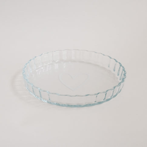 Tarteform aus Glas mit Herzmotiv, stilvoll auf hellem Untergrund fotografiert