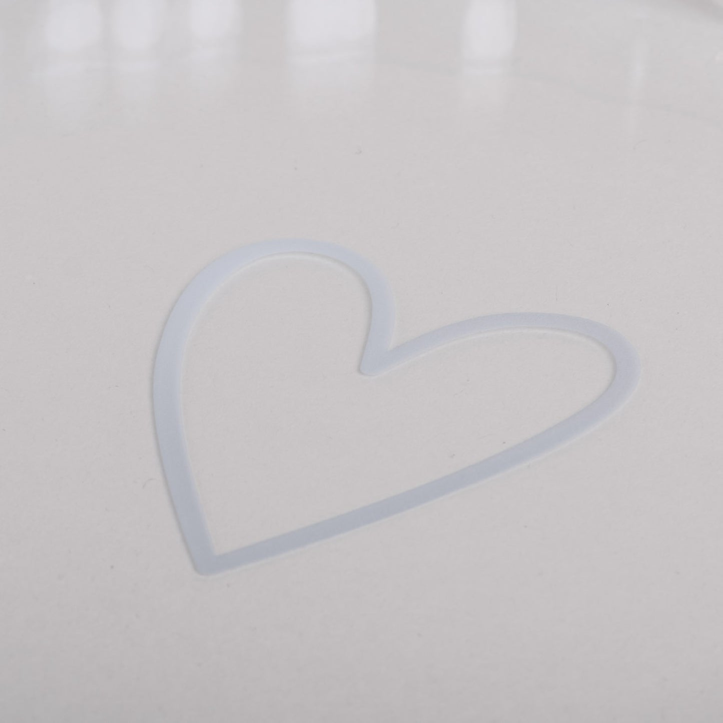 Nahaufnahme des weißen Herzprints auf dem Boden der großen Tarteform Herz aus Glas.