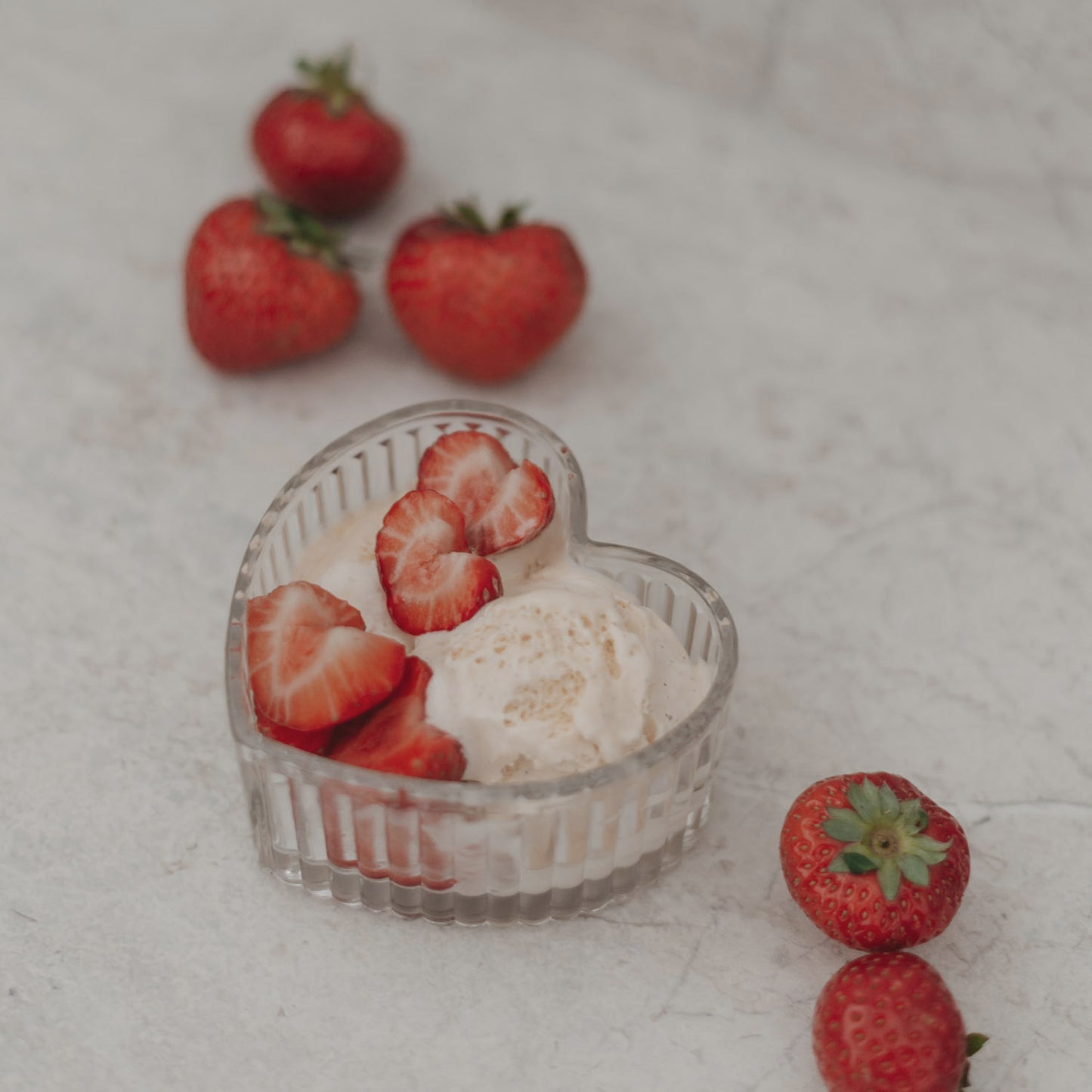 Herzschale gefüllt mit Erdbeeren und Eiscreme, perfekt für liebevolle Dessertpräsentationen.
