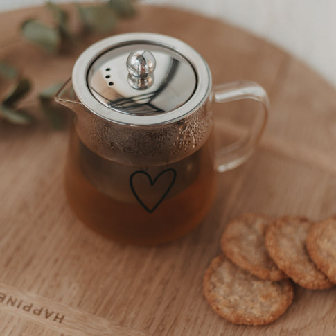 Obenansicht der gefüllten Teekanne Herz mit glänzendem Deckel und stilvollem Herzdesign aus Glas