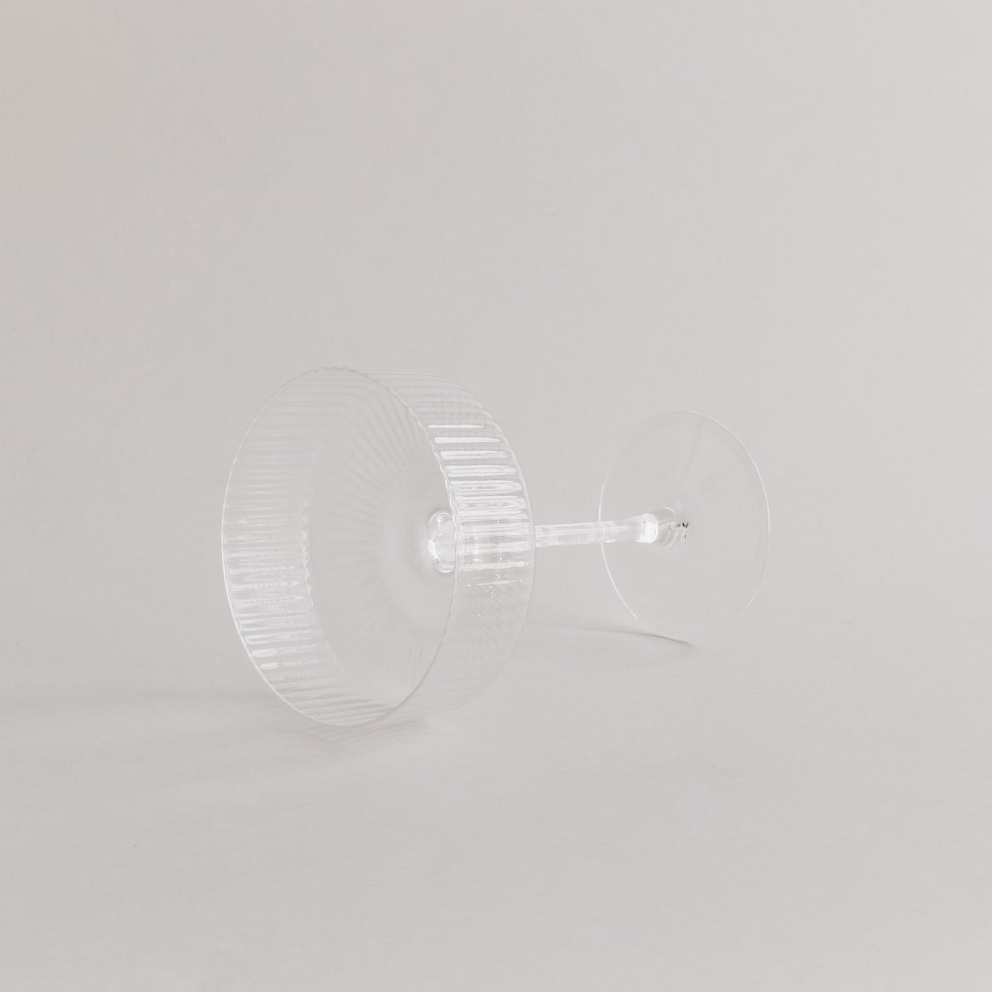 Produktaufnahme des leeren Champagnerglases in Seitenlage, edles Rillendesign sichtbar.