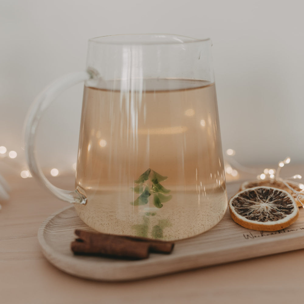 Karaffe mit gefülltem Getränk und Tannenfigur – perfekte Ergänzung für winterliche Genussmomente.