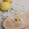 Minimalistisches Trinkglas mit Zitronen Design, klares Glas für Wasser auf Holztablett