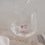 Trinkglas mit rosa Schwein im Boden, Wasser wird eingegossen, modernes Glasdesign
