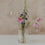 Hoher Glasbehälter mit weißem Wildblumen-Motiv und Holzdeckel, als Vase mit bunten Wiesenblumen dekoriert