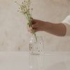 Glasvase mit Herzmuster, dekoriert mit frischen Wiesenblumen