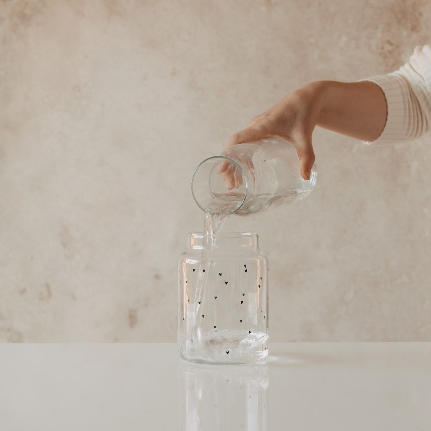Glasvase mit Herzprint wird mit Wasser befüllt