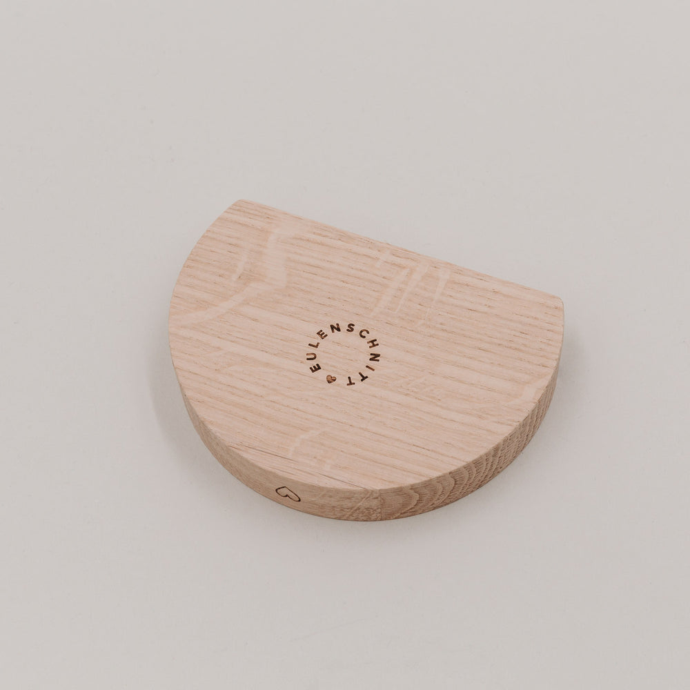Rückseite des halbmondförmigen Holz-Teelicht-Kartenhalters mit eingraviertem Eulenschnitt-Logo und Herzdetail.