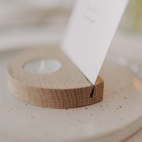 Detailaufnahme des Kartenhalters aus Holz mit Teelicht und eingesetzter Karte in der Schlitzhalterung.