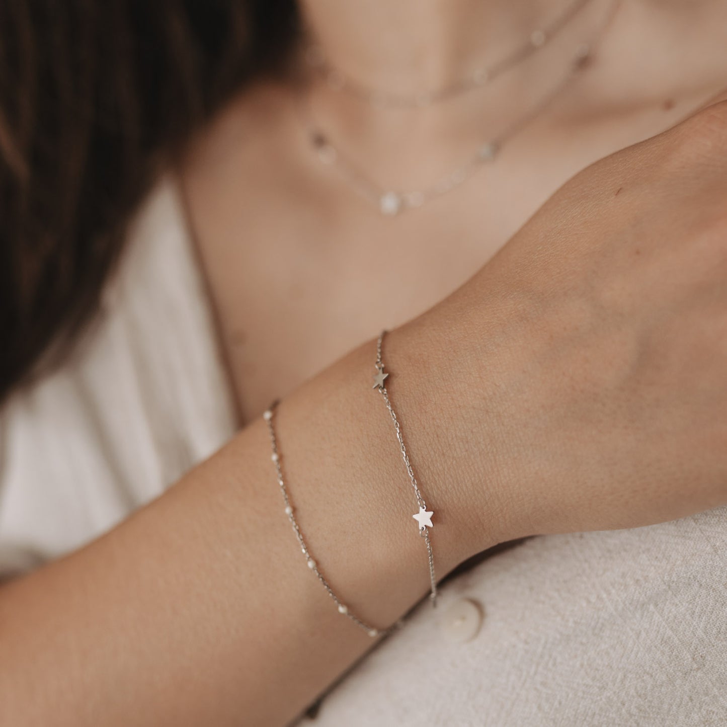 Jackie Silber Armband kombiniert mit zweitem Armband im Layer-Look, getragen am Handgelenk.