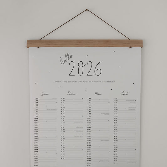 Wandkalender 2026 mit Holzleiste, Aufschrift „hallo 2026“ und liebevollem Zitat – Monatsübersicht.