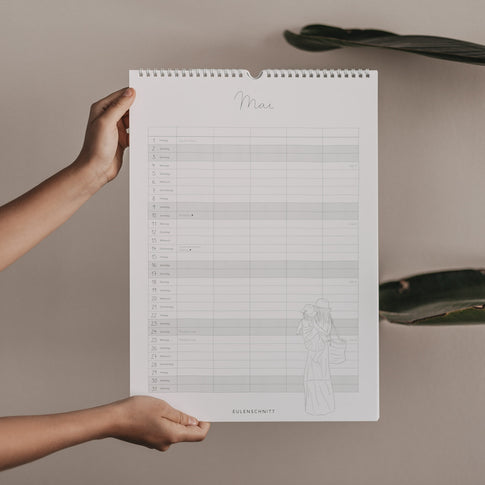 Familienkalender 2026 mit Monatsübersicht Mai, zarter Illustration von Mutter mit Kind und spiralförmiger Aufhängung.