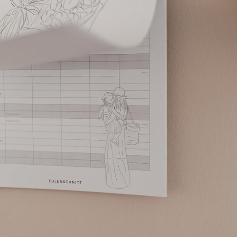Familienkalender 2026 an der Wand mit Monatsübersicht und Illustration von Mutter mit Kind in sanften Linien.