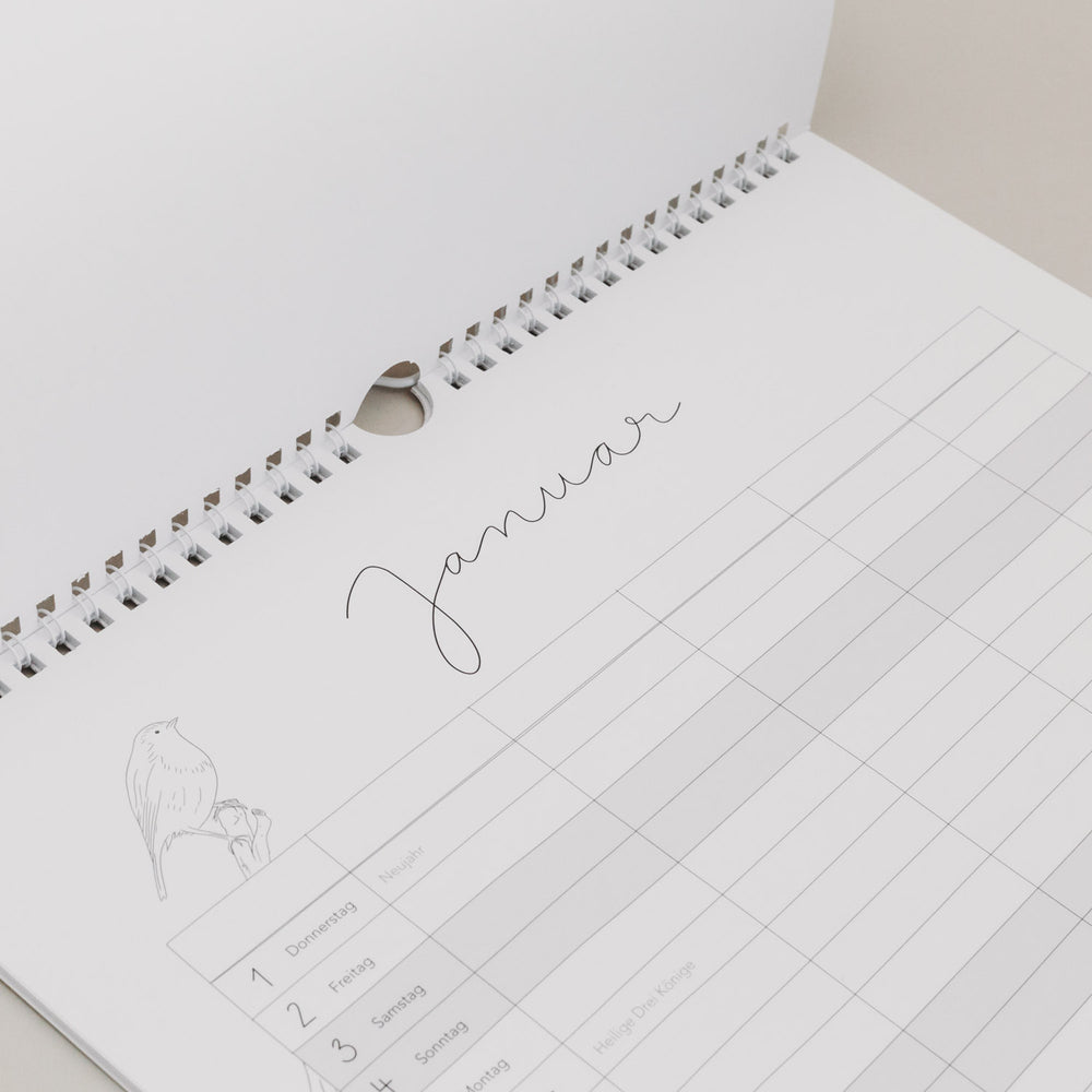 Familienkalender 2026 mit Monatsübersicht Januar, feiner Illustration und Aufhängung in Spiralbindung.