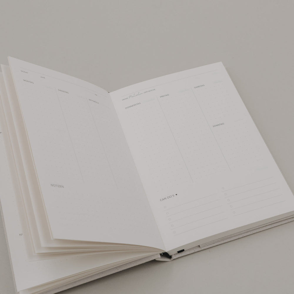 Undatierter Kalender „Neues Glück“ geöffnet mit Wochenübersicht und Punktlayout für Termine, Notizen und To-dos