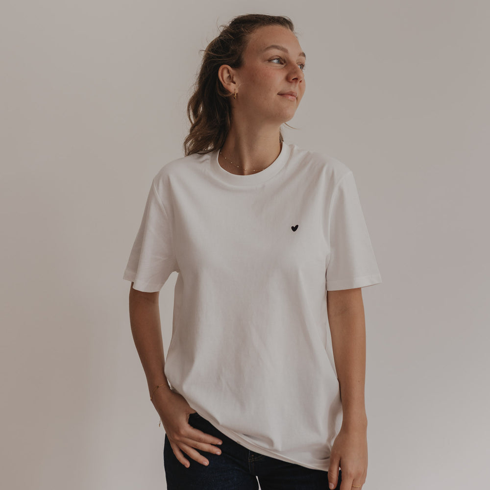 Frau trägt weißes Shirt mit schwarzem Herzprint vorne, locker und casual