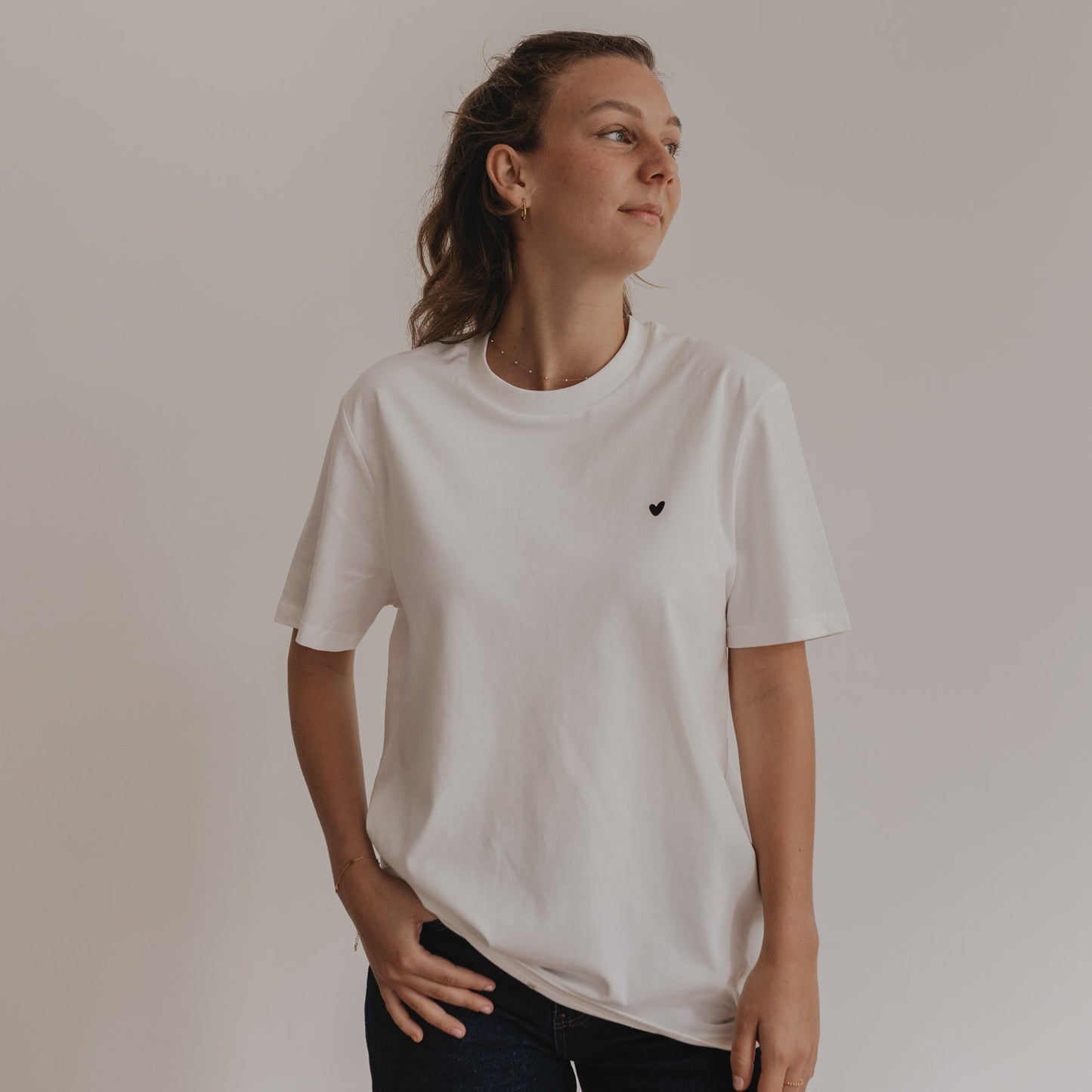 Frau trägt weißes Shirt mit schwarzem Herzprint vorne, locker und casual